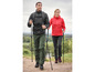 Twee personen in wandelkleding met wandelstokken op een pad.