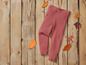 Roze leggings op een houten achtergrond met herfstbladeren