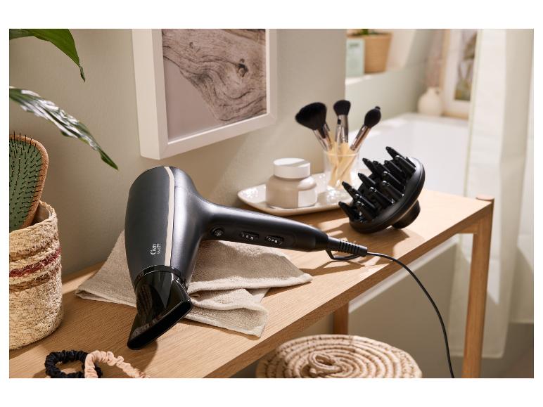 Föhn en diffuser op een houten tafel met beautyaccessoires in een badkameromgeving.