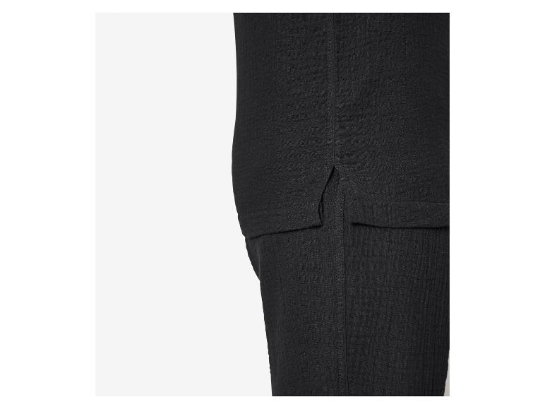 Close-up van zwarte getextureerde stof met zijsplit en naaddetail.