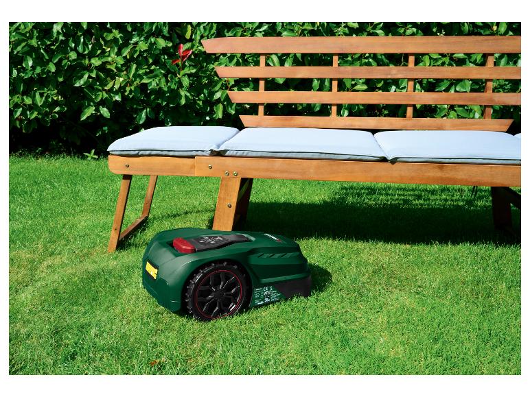 Parkside robotmaaier voor een houten bank met kussens in een tuin.