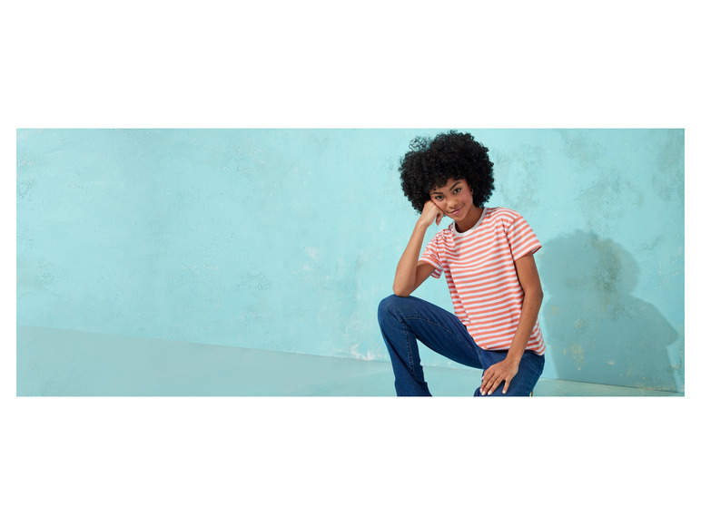 Een vrouw draagt een gestreepte T-shirt en een spijkerbroek.