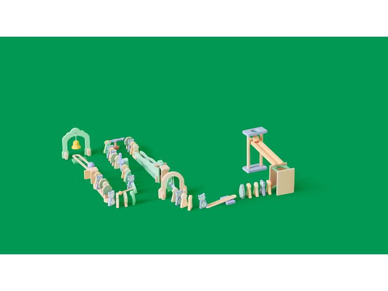 Houten dominostenen en knikkerbaan op een groene achtergrond.