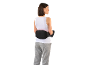 Vrouw met elektrische lendenmassage en grijze joggingbroek.