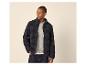 Man in donkere fleece jas en lichte trui, met hand in zak.
