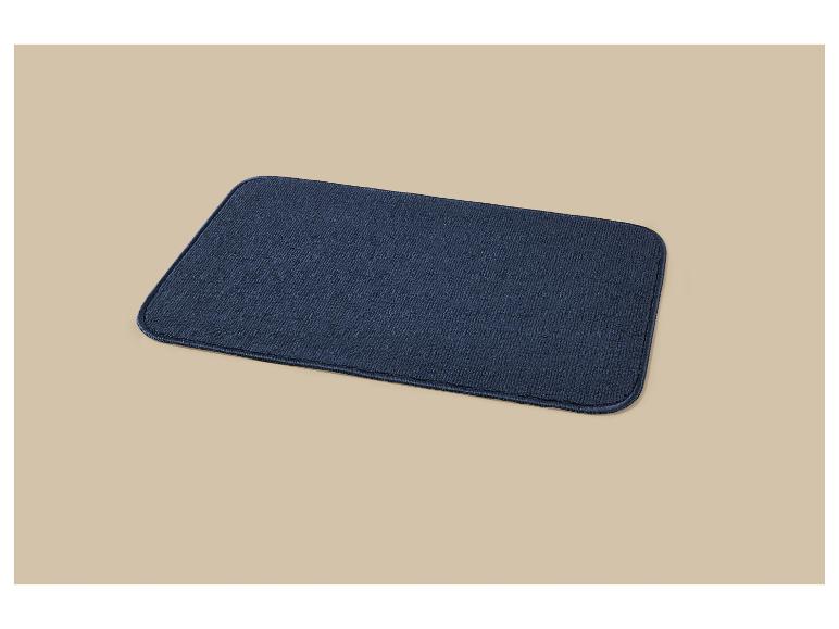 Donkerblauwe rechthoekige deurmat of tapijt op een beige achtergrond.