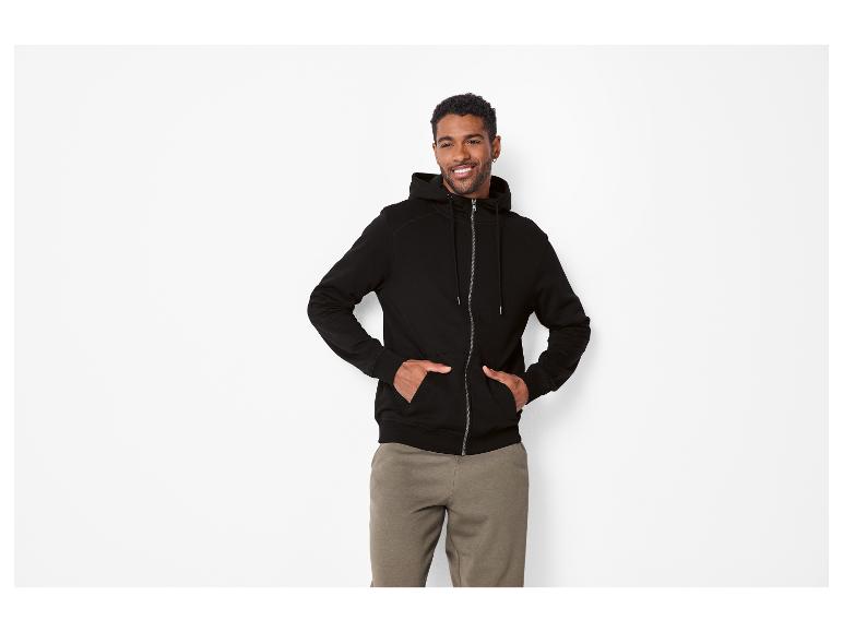 Man in zwarte hoodie met rits en kaki joggingbroek