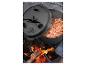 Gietijzeren Dutch Oven met chili die boven open vuur kookt, deksel deels open.