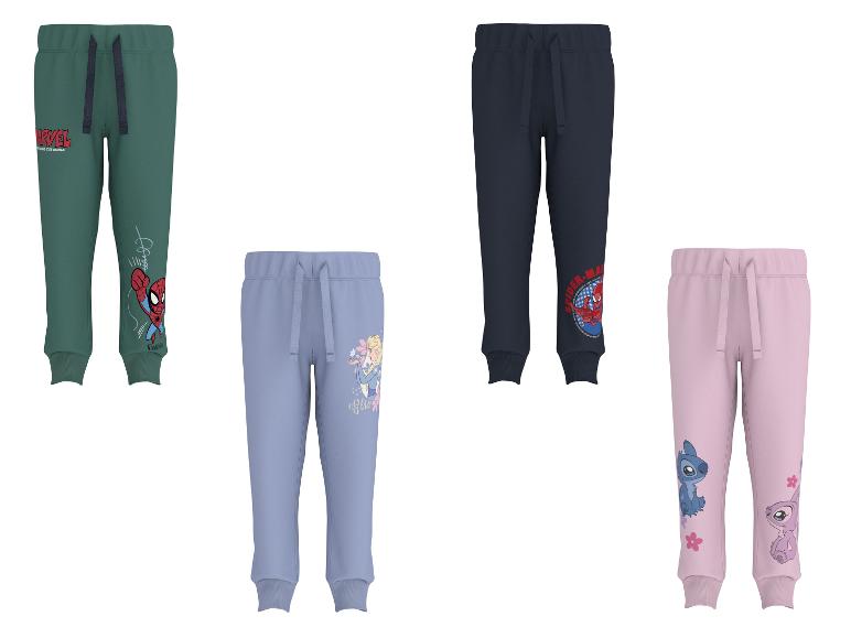 Vier kinder joggingbroeken in groen, blauw, marineblauw en roze met diverse karakterprints.