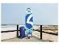 Paddleboard en rugzak op een houten terras aan zee.