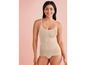 Een vrouw draagt een beige, naadloze, corrigerende tanktop.