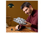 Een man houdt een LEGO Star Wars Millennium Falcon vast.