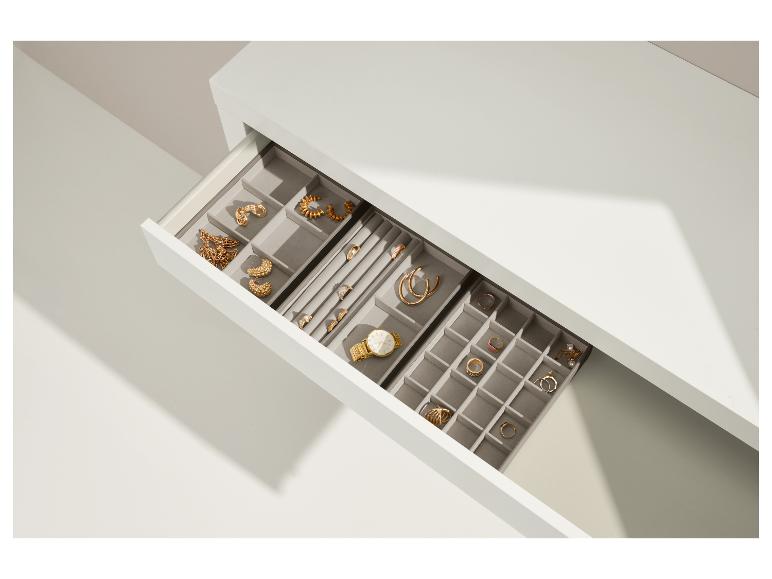 Open lade met sieradenorganizer, gouden kettingen, oorbellen, ringen en een horloge.