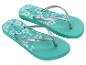 Turquoise teenslippers met bloemenpatroon en “Copacabana” tekst.
