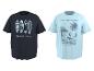 Twee T-shirts met korte mouwen: een donkere met surfplanken en 'GOLDEN HOUR', en een lichtblauwe met een surfer, palmboom en 'RIDE THE WAVES CALIFORNIA'.