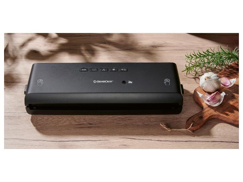 SilverCrest vacuümsealer op een houten tafel, met knoflook en rozemarijn.