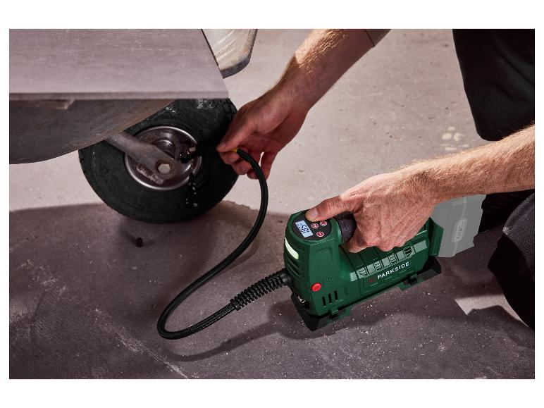 Een man pompt een kruiwagenwiel op met een draagbare Parkside compressor.