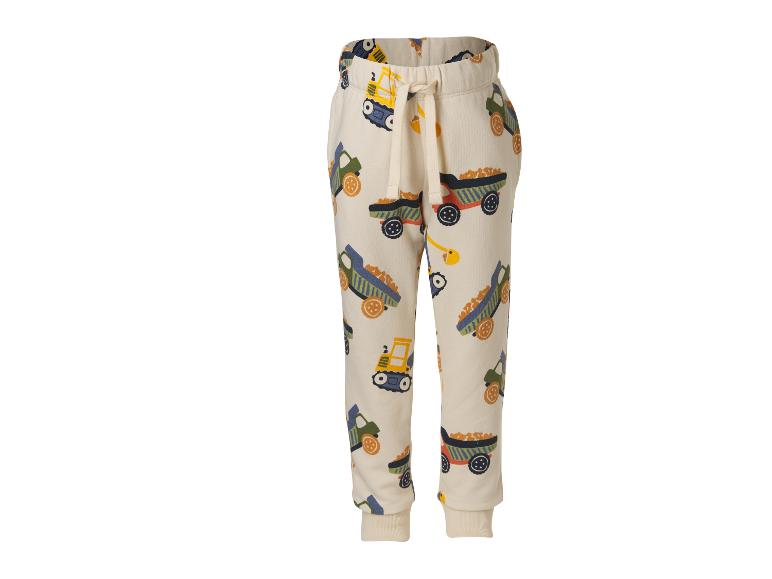 Beige joggingbroek voor kinderen met bouwvoertuigenprint.