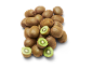 Een stapel hele en gehalveerde kiwi's op een zwarte achtergrond.