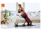 Vrouw traint met CRIVIT 6 kg kettlebell en rugtrainer.