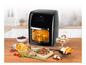 Een zwarte Gourmetmaxx airfryer met een gebraden kip erin, omringd door gefrituurde frietjes, snacks en gedroogd fruit.