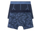 Twee boxershorts, één effen donkerblauw en één met bladerenprint.