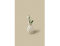 Witte spiraalvormige vaas met witte bloemen op een beige achtergrond.