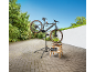 Elektrische fiets op een reparatiestandaard met gereedschap op een houten krukje.