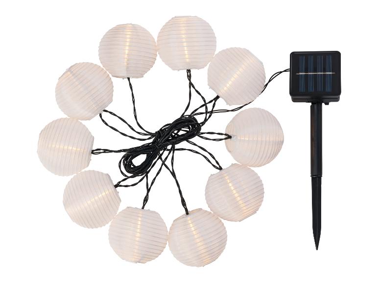Solar lichtslinger met witte ronde lantaarns en zonnepaneel.