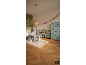 Kind tekent aan tafel in een bos-thema kinderkamer met meubels en decoraties.