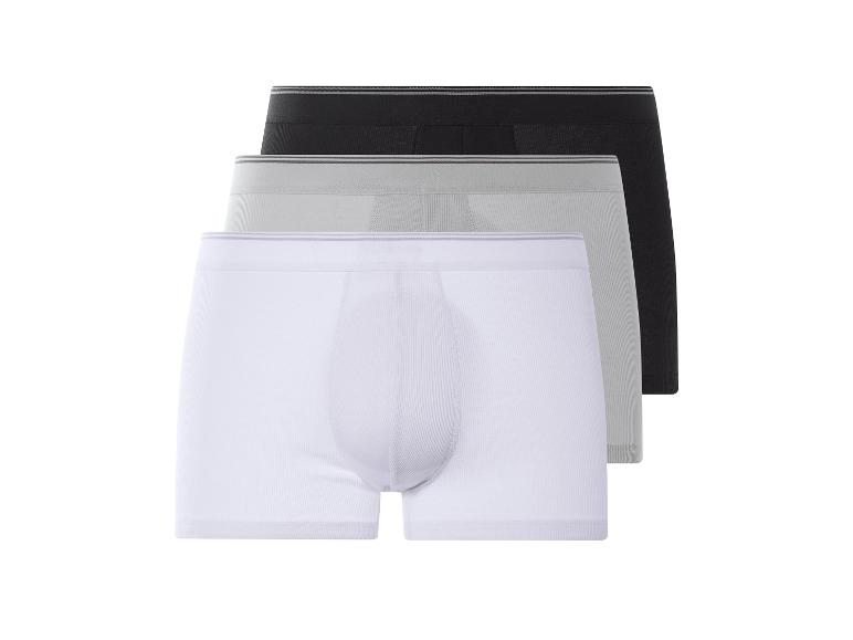 Drie effen boxershorts: wit, grijs en zwart.