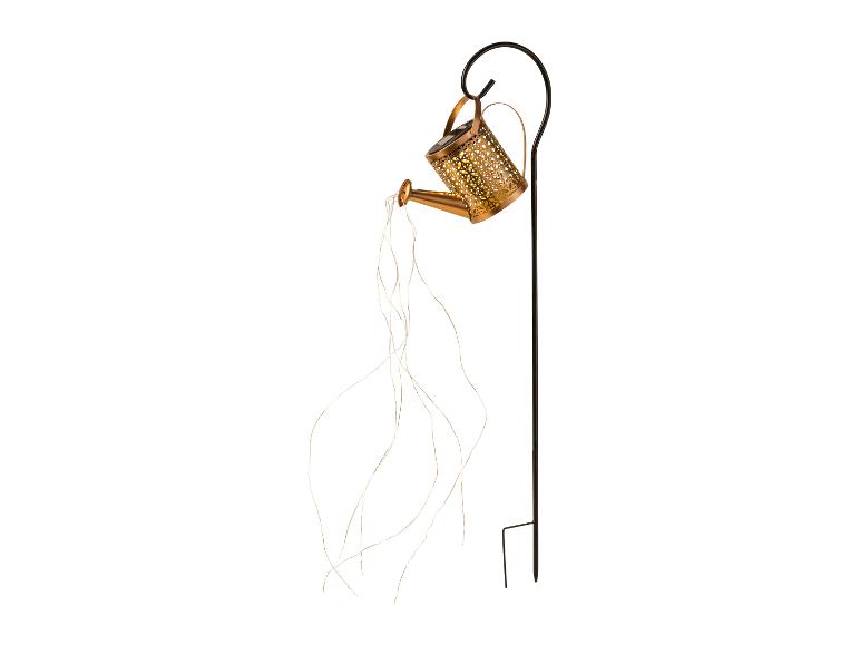 Decoratieve gieter met LED-lampjes hangend aan een zwarte paal.
