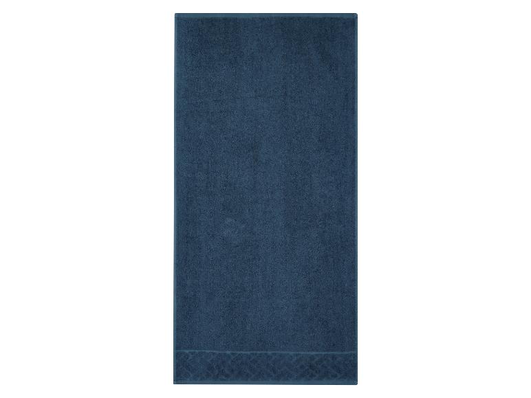 Donkerblauwe badhanddoek met een decoratief patroon aan de onderkant