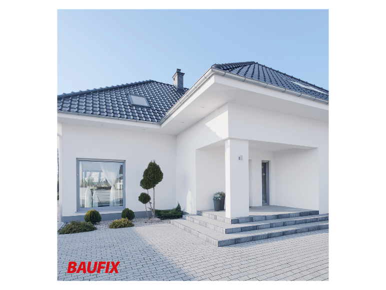 Modern huis met dakpannen, bestrating en tuin.