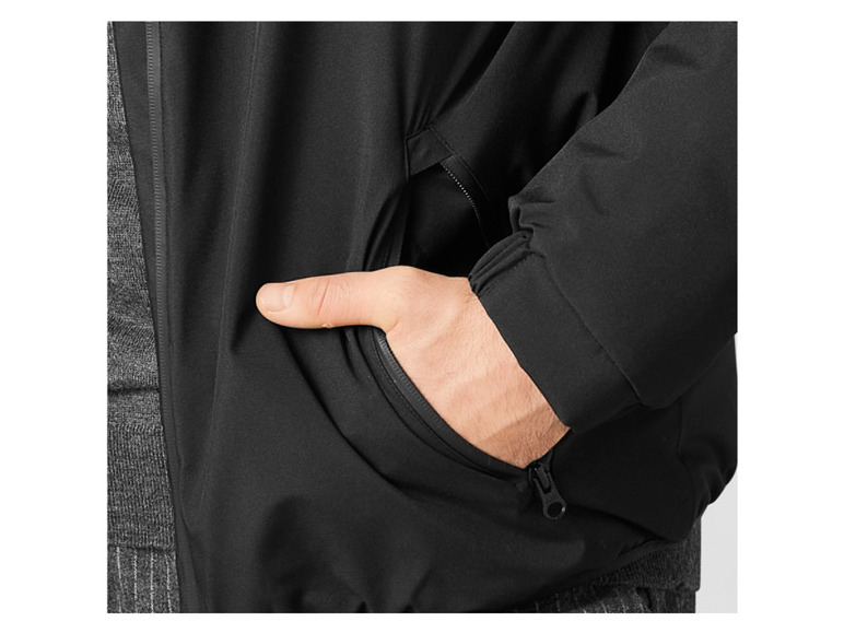 Een close-up van een zwarte jas met een ritszak.