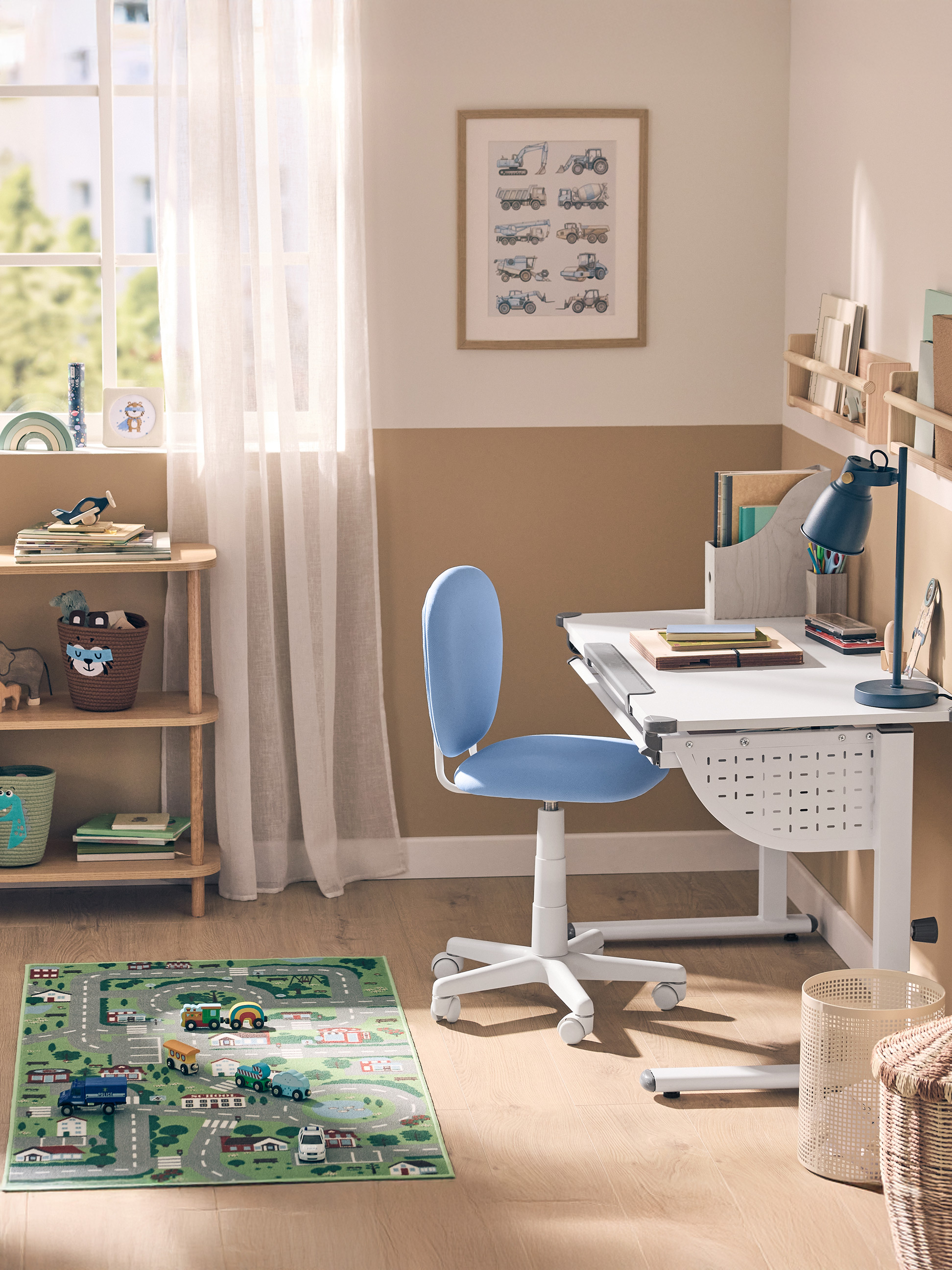 Kinderkamer met een wit bureau, blauwe stoel, houten plank en speelkleed.