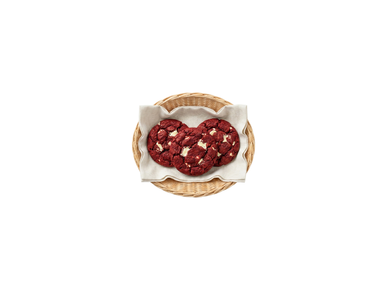 Drie red velvet cookies met stukjes witte chocolade in een klein mandje