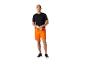 Man in zwart t-shirt en oranje shorts, een waterfles vasthoudend.