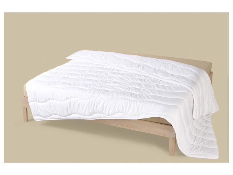Wit dekbed op een houten bedframe