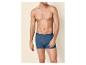 Man zonder shirt in blauwe katoenen boxershorts.