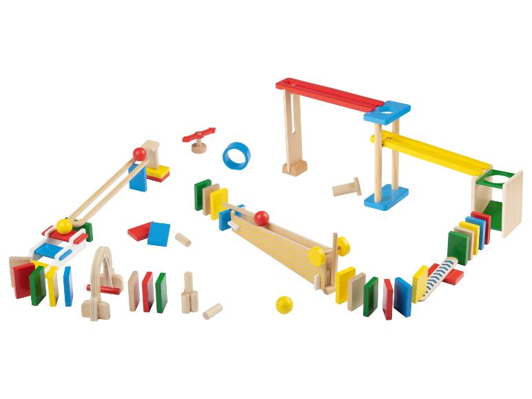 Een kleurrijke houten speelset met ballen en dominostenen voor een kettingreactiebaan.