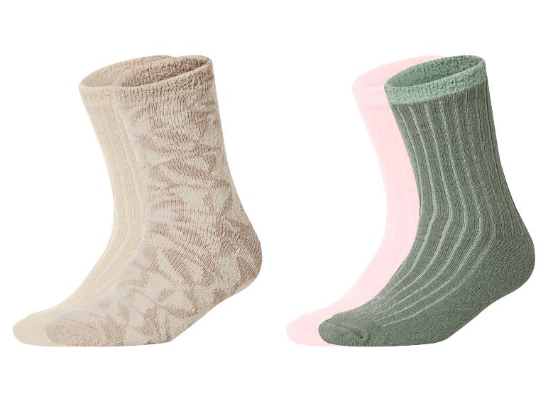 Twee paar sokken: één beige met patroon en één groen met een roze sok erachter.