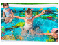 Kinderen spelen in een opblaasbaar zwembad met een onderwaterthema.