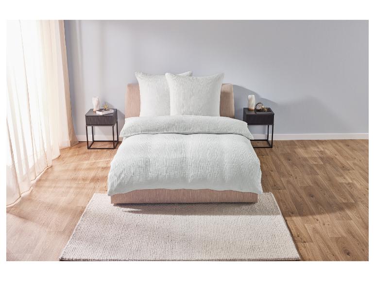 Wit beddengoed met twee kussens op een bed in een slaapkamer