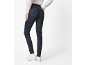 Vrouw in donkere jeans en wit overhemd, van achteren gezien.
