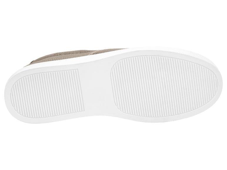 Zool van een beige sneaker met een witte rubberen zool en verticale strepen.
