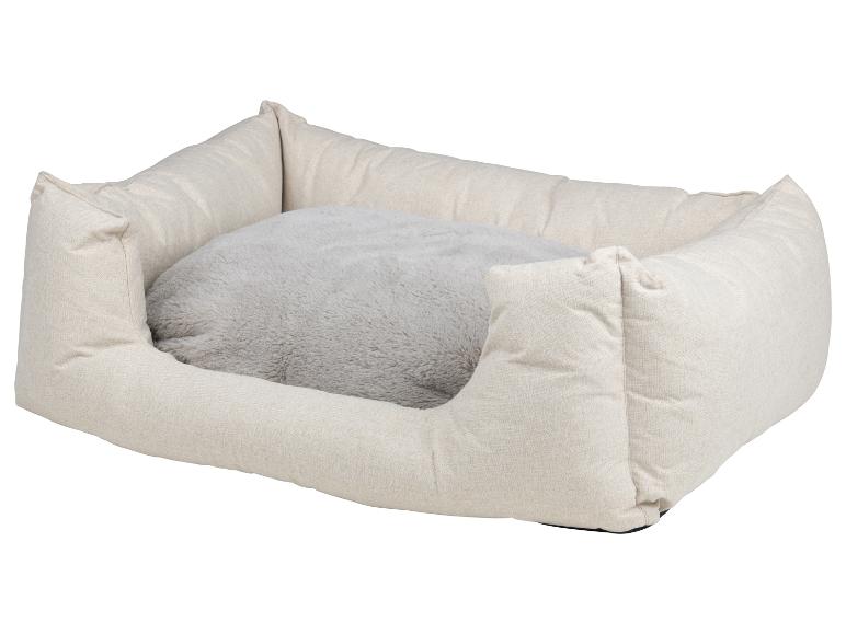 Beige hondenbed met een grijs pluche kussen.