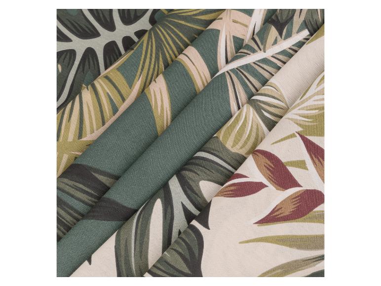 Stoffen met tropische print, waaronder groene bladeren en rode bloemen.