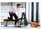 Man traint met dumbbells op een CRIVIT halterbank en Bodenschutzmatte.