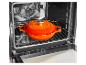 Oranje gietijzeren pan in een oven op een rooster